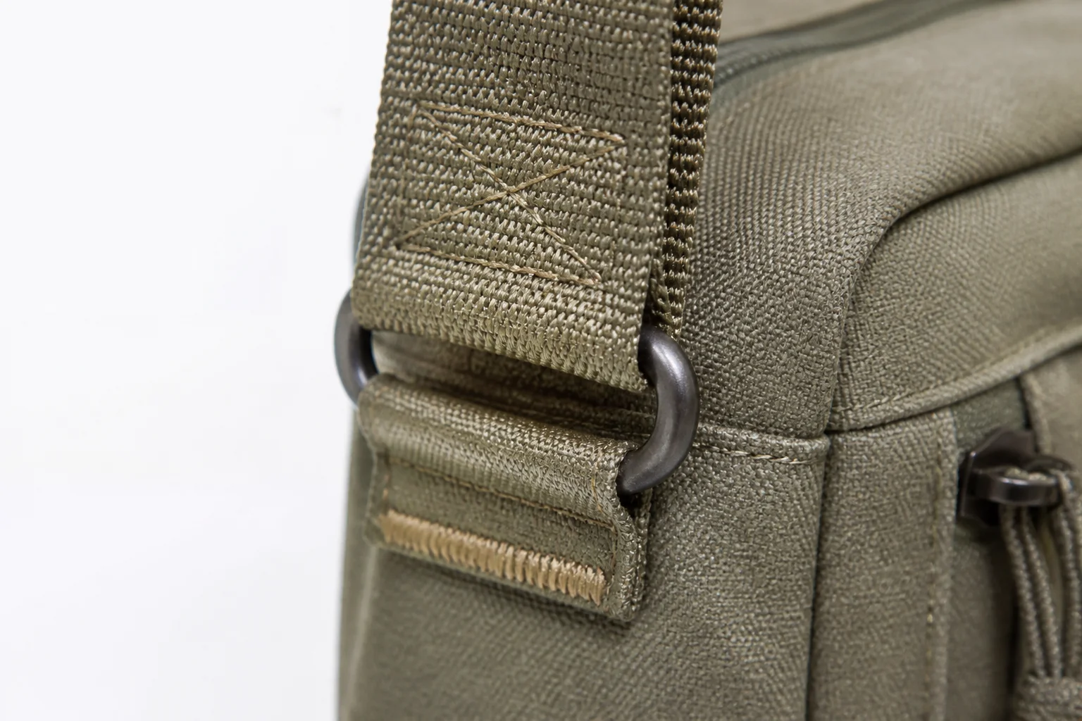 Close-up of a bag strap attachment with reinforcement and D-ring