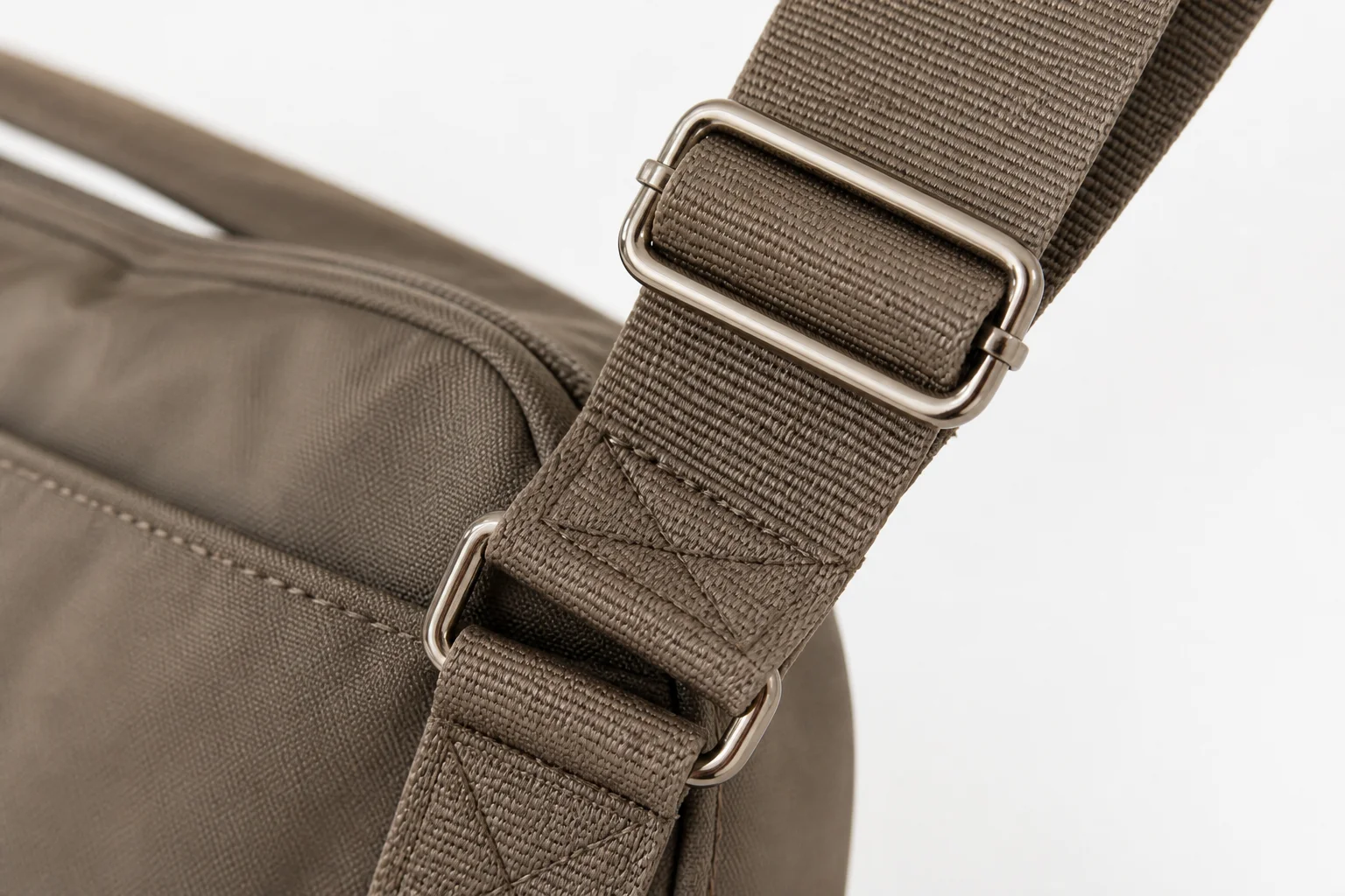 Adjustable shoulder strap with metal slider and reinforced attachment point