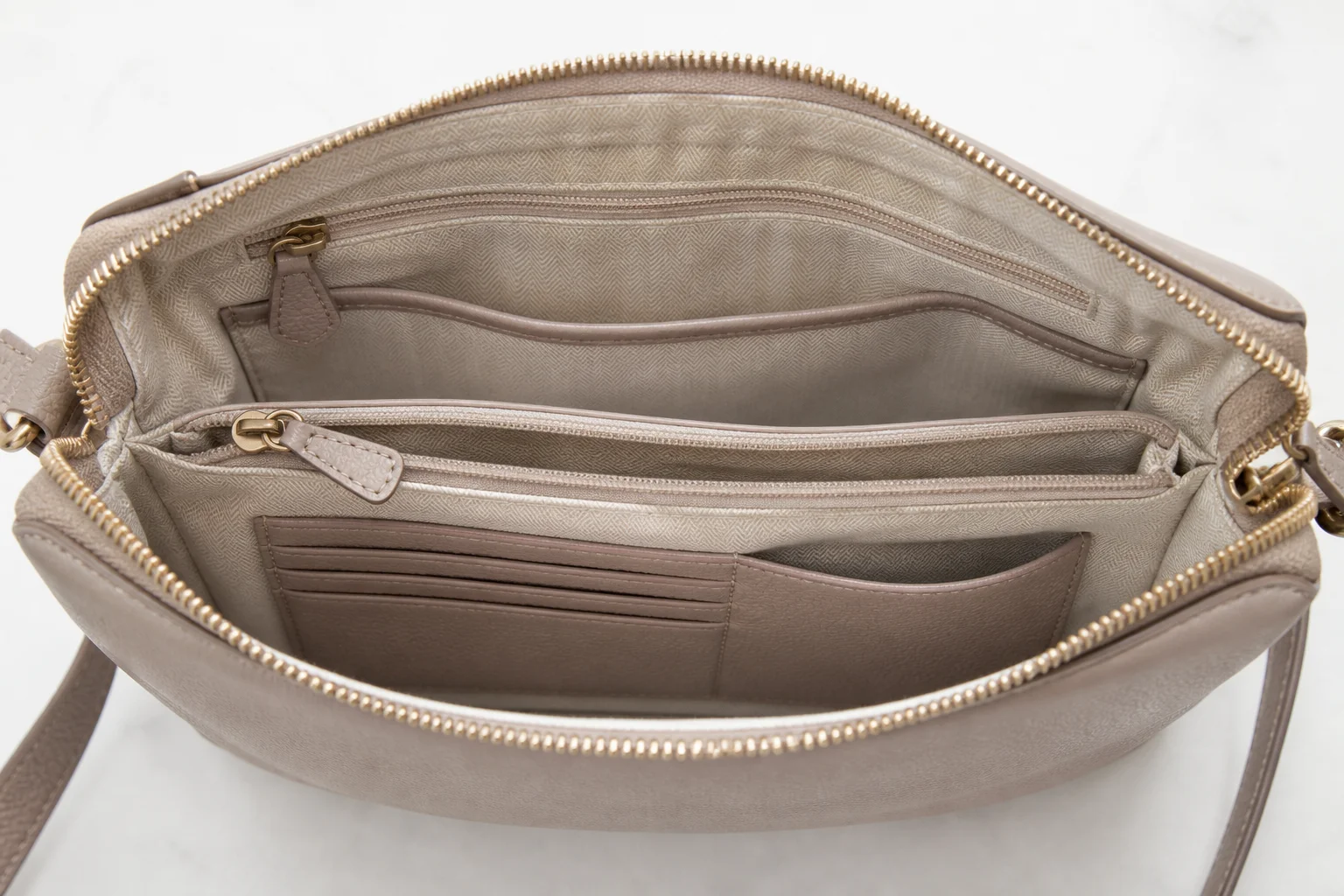 Crossbody bag interior with zipped compartments, slip pockets and card slots