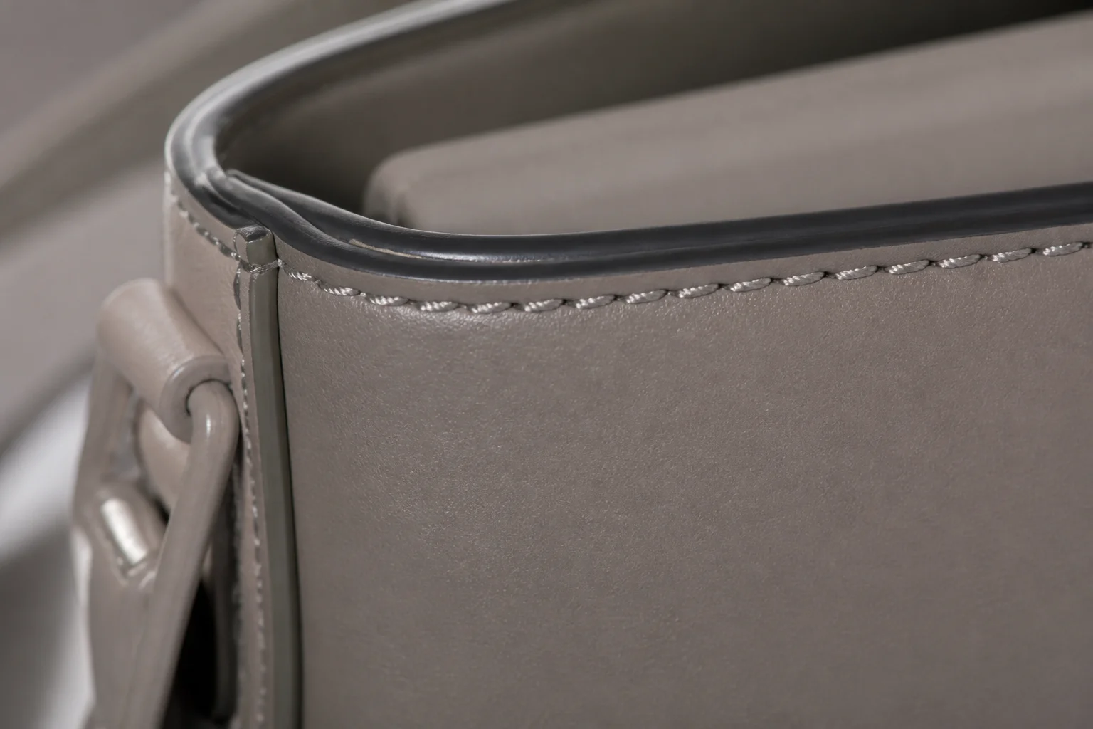 Close-up of fine edge painting and precise tonal stitching on a matte PU leather bag panel