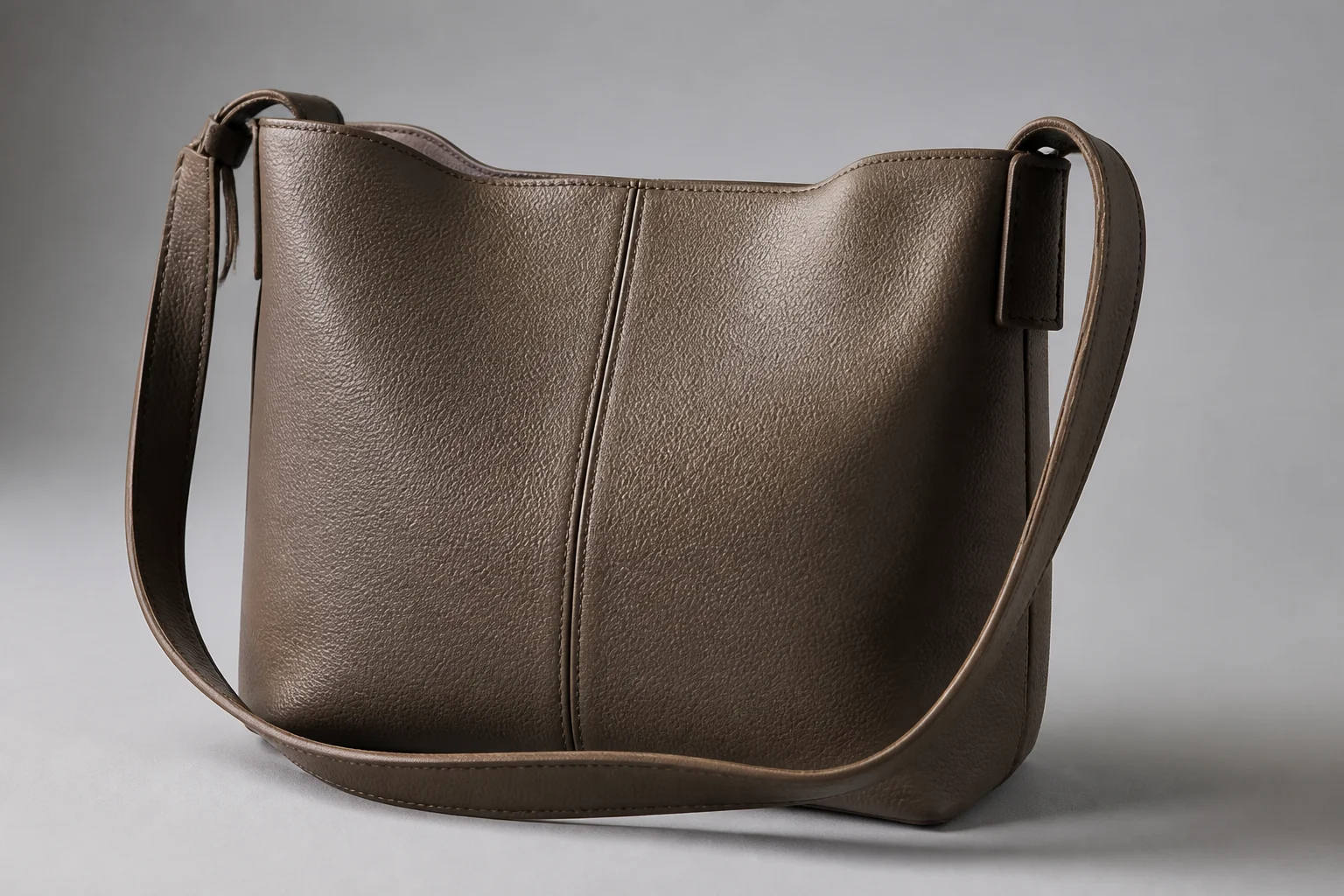 Understated matte PU leather bag with no visible logo under soft directional lighting