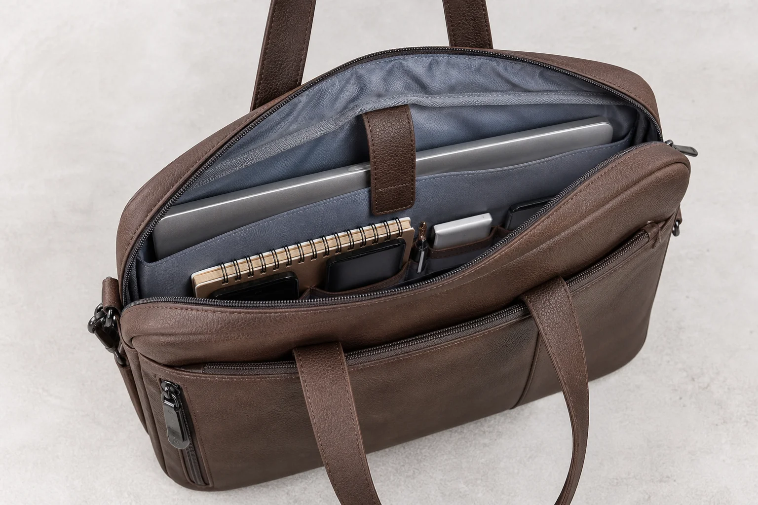 PU leather tote bag opened to show a padded laptop compartment and internal organisation